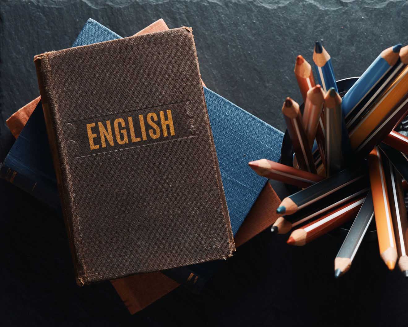 english book with color pencils next to it