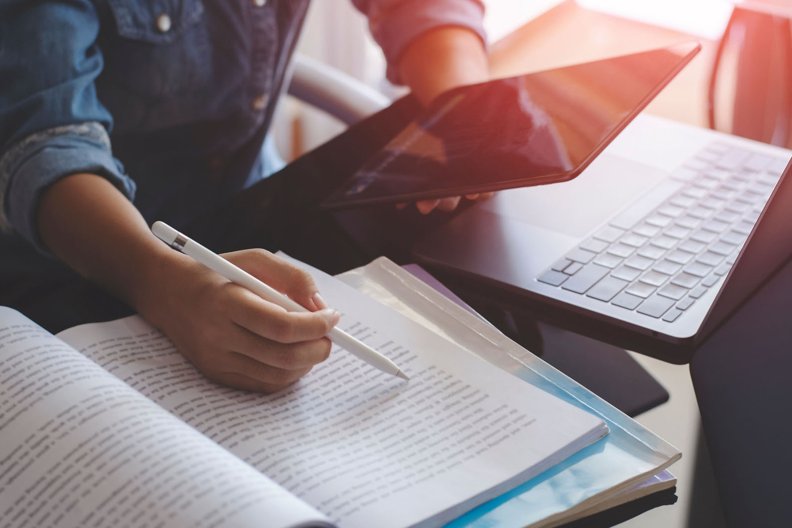 person studying with a book and tablet