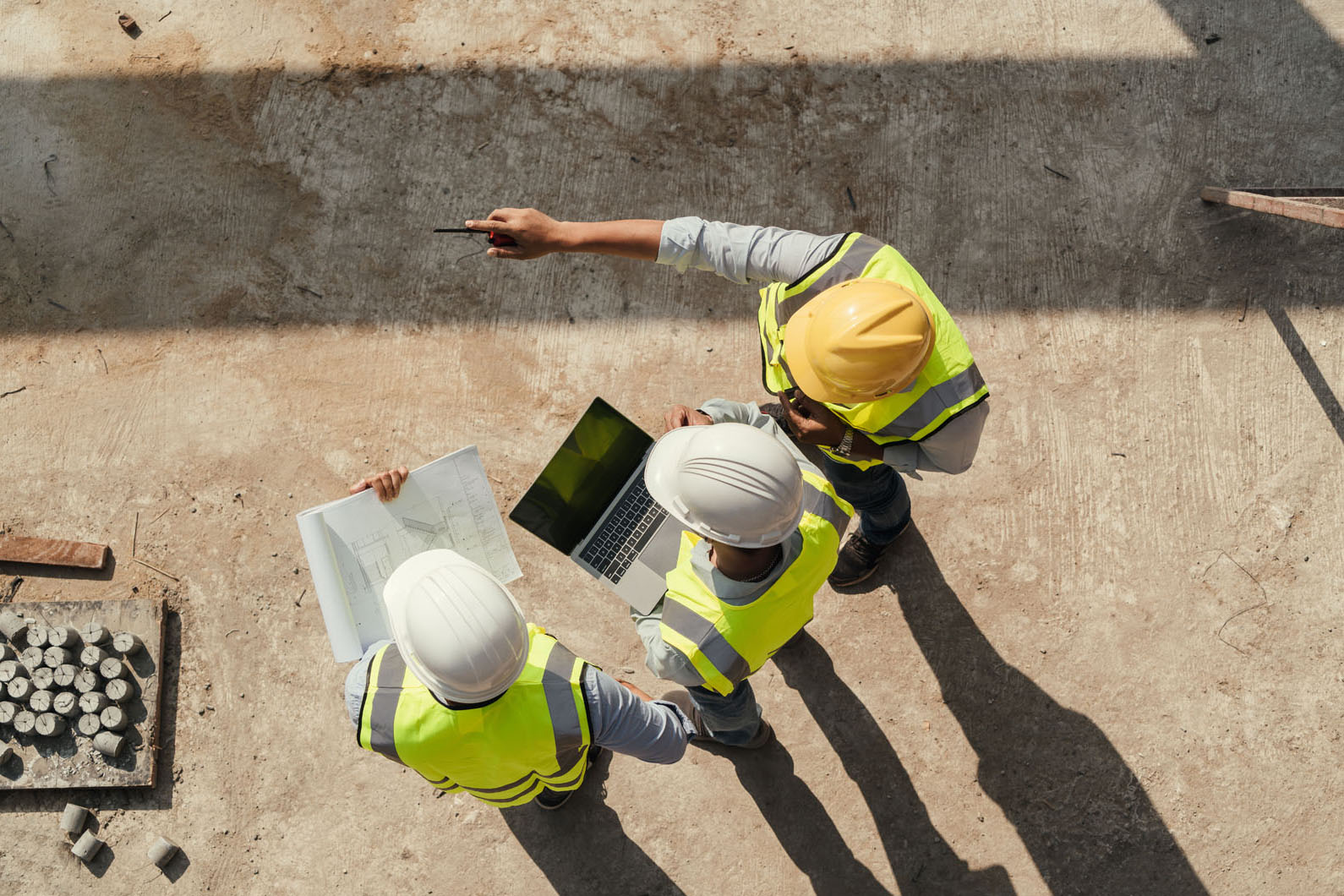 team of 3 at a work site wearing hard hats